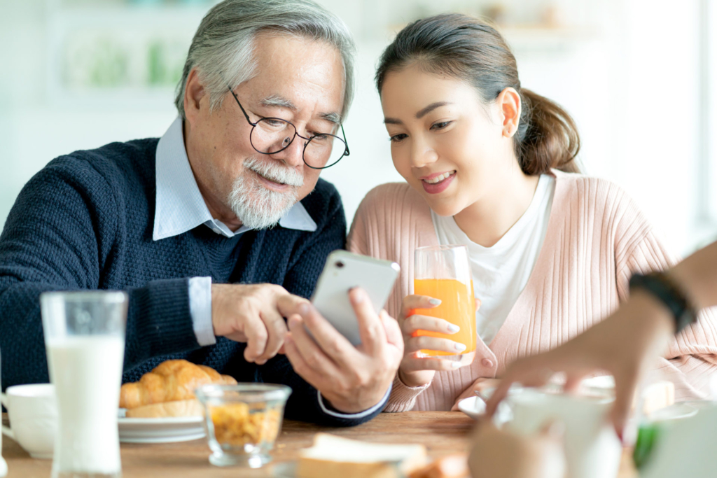 孫とスマホを見る高齢者